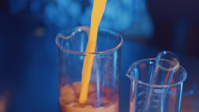 Pouring glowing liquid into beaker in science laboratory
