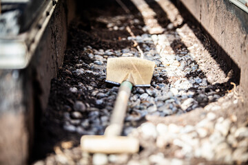 spade and gravel residues lie on an old bitumen roof covering