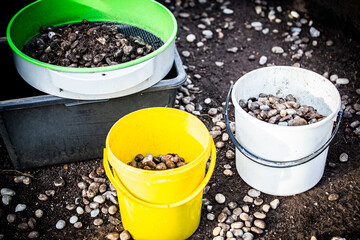 Gravel is cleaned in a garden sieve