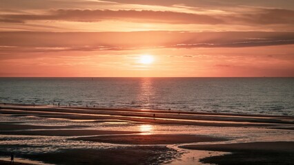 Sunset over beach with reflection in water