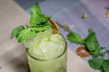 Glass cup of fresh iced lemonade with green mint.