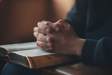 hands in prayer on a holy book