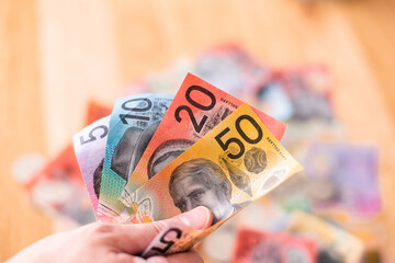fanned out Australian money with more cash in the background