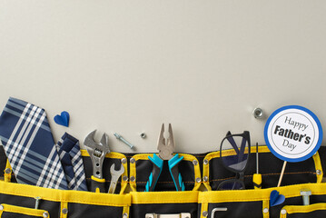 A creative display featuring tools, a blue and white tie, and a Happy Father's Day sign, all neatly...