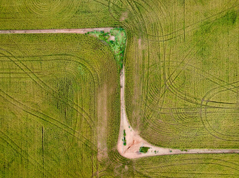 Aerial view of harvester lines and patterns in a rural paddock with a zig zag fence line