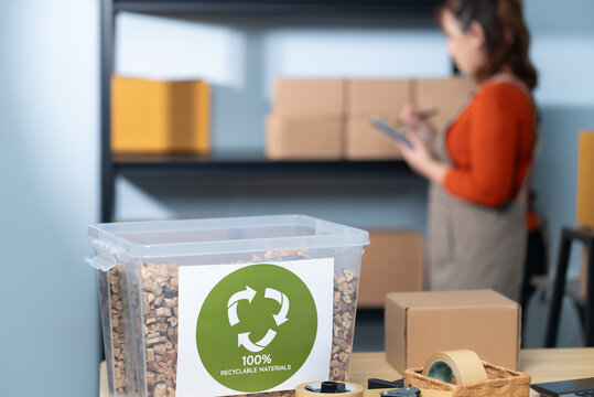 The focus is on a container labeled "100% Recyclable Materials" filled with eco-friendly cushioning made from water hyacinth highlighting the sustainable practices of a small business