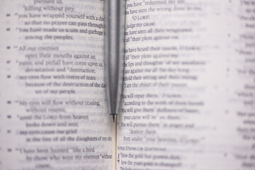 Top shot of an open Christian Bible with a pen depicting Bible study and fellowship