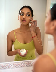 Face, cream and mirror for skincare, cosmetic and moisturiser in reflection in home. Bathroom,...