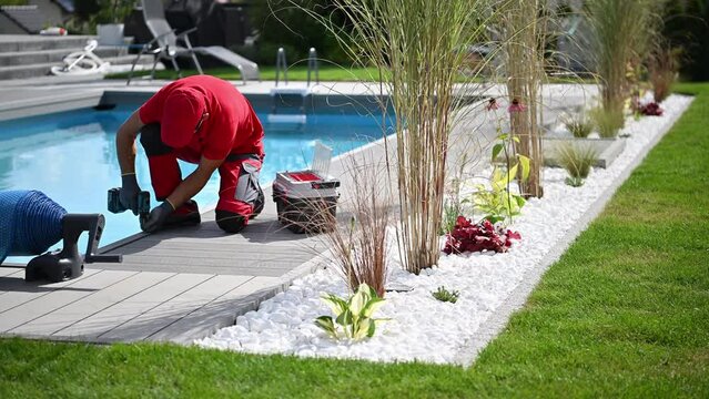 Man in Red Shirt Working on a Poolside 