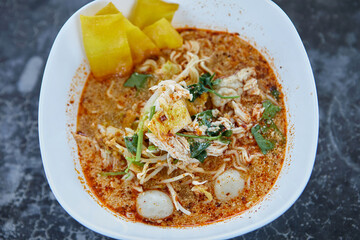 Spicy tom yum rice stick noodles with chicken meat