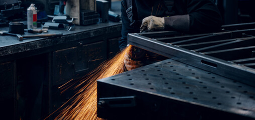 Hands of worker grinding a piece of metal