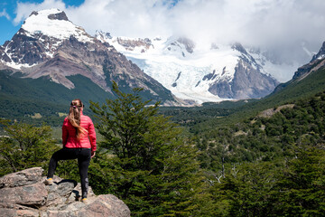 Naklejka premium Mujer turista parada sobre roca mirando los paisajes de la Patagonia Argentina, en El Chalten