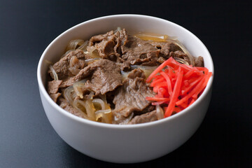 黒背景の紅生姜がのった牛丼の写真