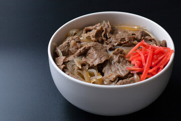 黒背景の紅生姜がのった牛丼の写真