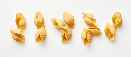 A group of dry Gigli or campanelle pasta arranged on a textured white background with ample room for text or other elements Perfect for cooking or advertising purposes