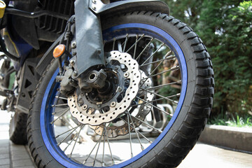 Fragment of a motorcycle with front wheel and brake disc. Close-up