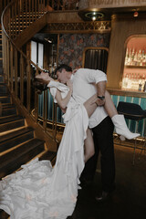 A young couple in wedding looks posing in a stylish loft bar.