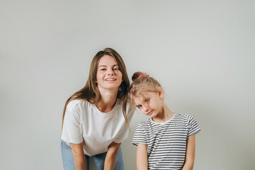 Young mother and her cute daughter looking at the camera.