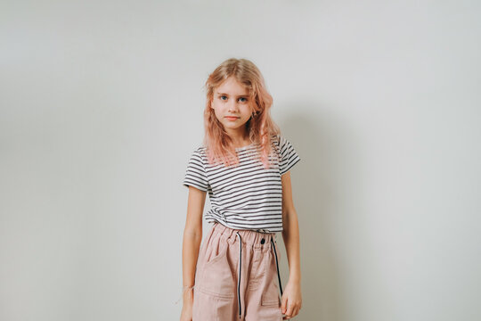 A 9-year-old girl stands against the wall.