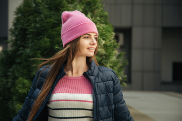 Portrait of a young woman with braces in a pink hat and blue jacket.