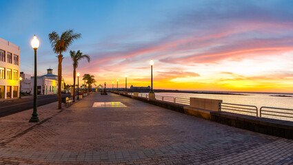 The Arrecife promenade in Lanzarote offers stunning ocean views at sunset, with palm trees, street lights and a romantic atmosphere ideal for relaxing walks.