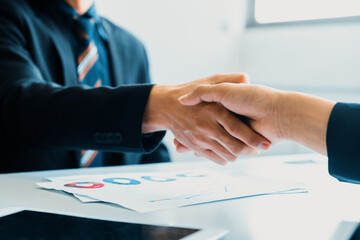 Business people agreement concept. Businessman and Asian businesswoman do handshake in the office....
