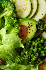 Green vegetarian salad with fresh vegetables, avocado and peanut dressing