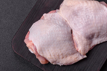 Raw chicken thighs with salt, spices and herbs