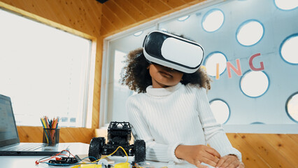 Creative girl wearing VR headset to learning in metaverse. Funny kid enjoy to wearing AI headset...
