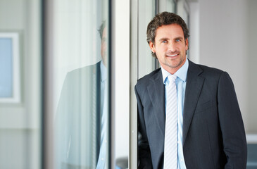 Businessman, window and happy in portrait at office for career or job growth with opportunities....