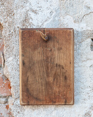 Old wooden blank signboard on the aged cement wall background
