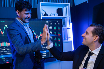 Two stock exchange traders making high five for successful in high profit chart investment at night...