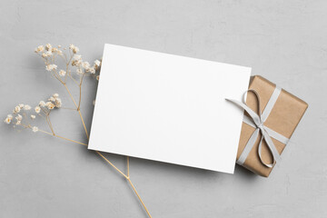 Blank greeting or thank you card mockup with gift box and dry flowers decor, blank card with copy...