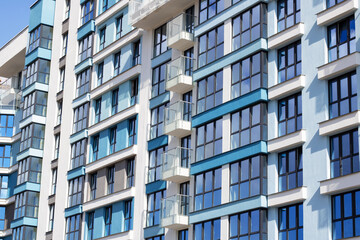 Fototapeta premium Urban design tower block with blue facade, numerous windows, and balconies