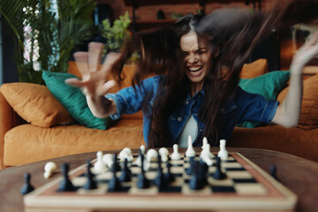 Strategic Mind Woman playing chess with flying hair, focused on the board