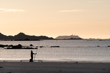 P&ecirc;cheur en surfcasting sur une plage de Bretagne en soir&eacute;e - France