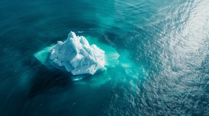 A stunning aerial view of a floating iceberg in a deep blue ocean, showcasing the natural beauty and majesty of polar ice formations.