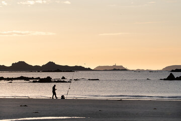 P&ecirc;cheur en surfcasting sur une plage de Bretagne en soir&eacute;e - France