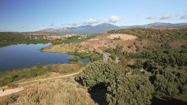 Mountain road next to the blue lake of Guadalix in the mountains of Madrid, Spain