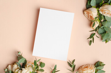 Wedding invitation card mockup with roses flowers on beige background, blank card with copy space