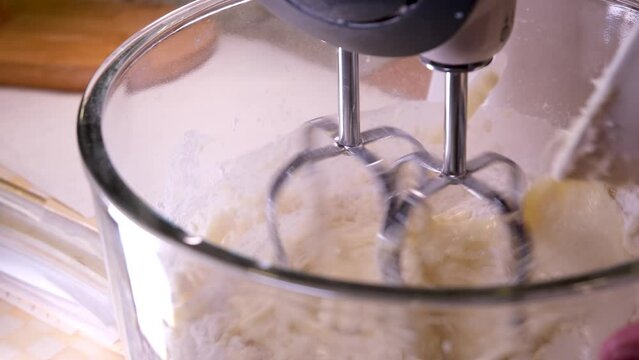 4K Close up bread dough making process by using flour mixing machine. Machine knead bread dough. Homemade bread raw mix with small machine. Food concept.