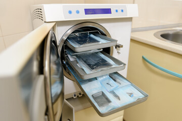 Sterilization of dental and surgical medical instruments. A dental assistant places medical steel...