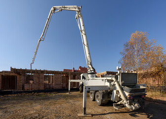 White truck mounted concrete pump with decomposed boom with hydraulic foot stabilizer support. The...