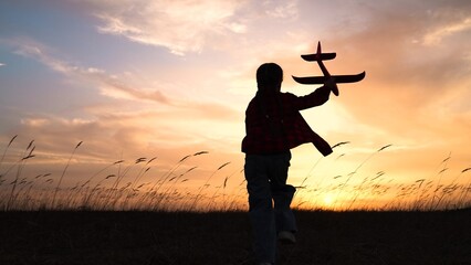 child kid girl with toy pilot runs into sunset dream flying flight, child with toy airplane, sunset...