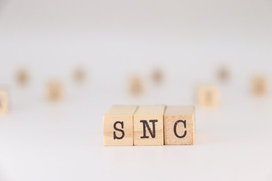 SNC letter written on wooden cubes isolated on white background.