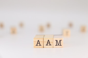 AAM acronym, Concept of All About Me written on wooden cubes isolated on white background.