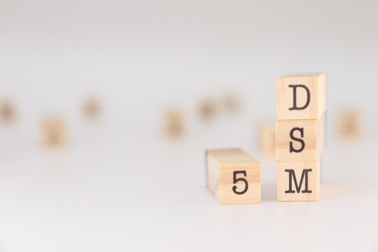 word dsm 5 written on wooden cubes isolated on white background