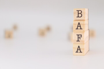 Bafa acronym. Concept of "brevet d'aptitude aux fonctions d'animateur" written on wooden cubes isolated on white background.