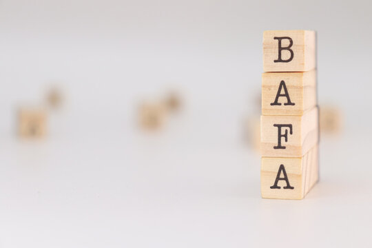 Bafa acronym. Concept of "brevet d'aptitude aux fonctions d'animateur" written on wooden cubes isolated on white background.