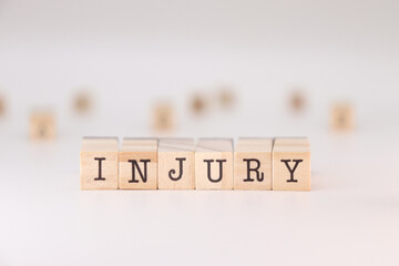Closeup of Injury word written on wooden cubes isolated on white background